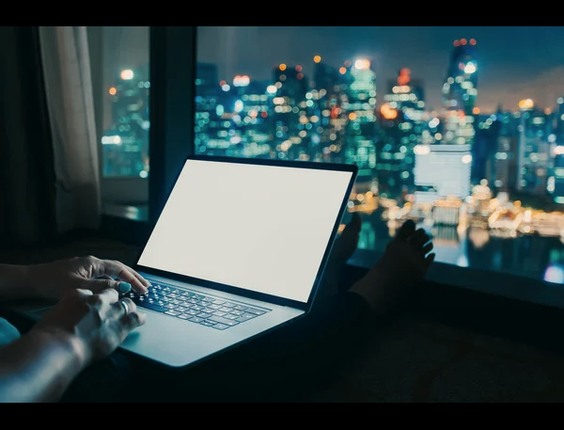 Laptop and notebook on a desk at night